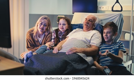 Elderly patient and visitors watching TV together