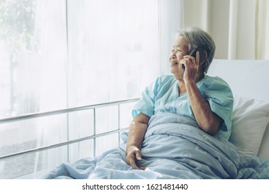 Elderly patients in hospital bed patients using smart phone call to descendant relatives feel happiness - medical and healthcare concept