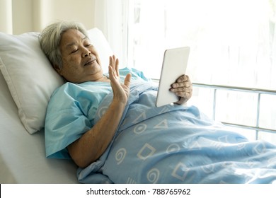 Elderly Patients In Hospital Bed Patients  Using Tablet Phone Smartphone Face Time 
 Call To Descendant Relatives - Medical And Healthcare Concept