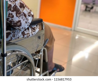 Elderly Patients Sitting On Wheelchair Waiting For The Doctor In Front Off Emergency Room, At Hospital, With Space For Text, Blur Background. Selective Focus.