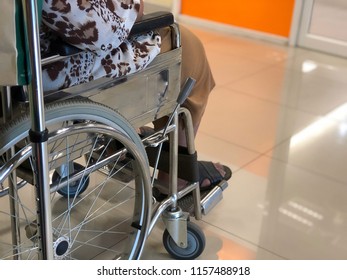 Elderly Patients Sitting On Wheelchair Waiting For The Doctor In Front Off Emergency Room, At Hospital, With Space For Text, Blur Background. Selective Focus.