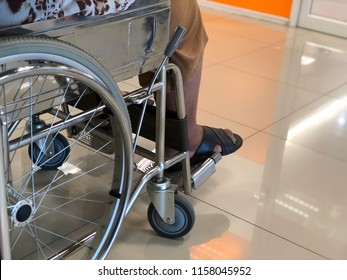 Elderly Patients Sitting On Wheelchair Waiting For The Doctor In Front Off Emergency Room, At Hospital, With Space For Text, Blur Background. Selective Focus.