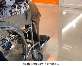 Elderly Patients Sitting On Wheelchair Waiting For The Doctor In Front Off Emergency Room, At Hospital, With Space For Text, Blur Background. Selective Focus.