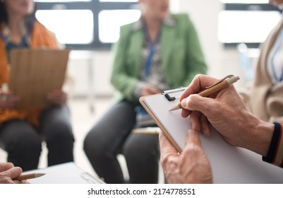 Elderly People Attending Group Therapy Session At Nursing House, Sitting In Circle, Having Conversation With Psychologist, Close-up