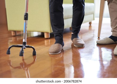 Elderly people and caregivers walking with a quadruped cane