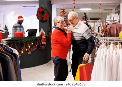 Elderly people doing sweet waltz dance in retail store, showing sincere feelings at mall during seasonal christmas promotions. Romantic man and woman dancing around in shopping center, xmas spirit. - Powered by Shutterstock