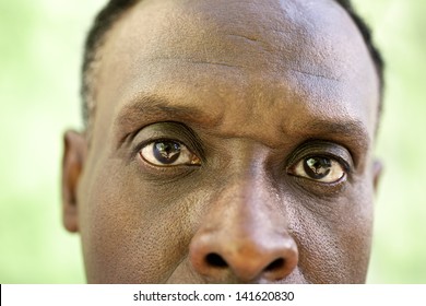 Elderly People And Emotions, Portrait Of Serious Senior African American Man Looking At Camera Against Green Wall