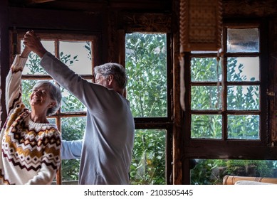 Elderly People Happy Lifesryle Activity With Two Senior Man And Woman Dancing Excited At Home For Love And Relationship - Mature Couple Have Fun At The Chalet During Holiday Vacation Or Mountains 