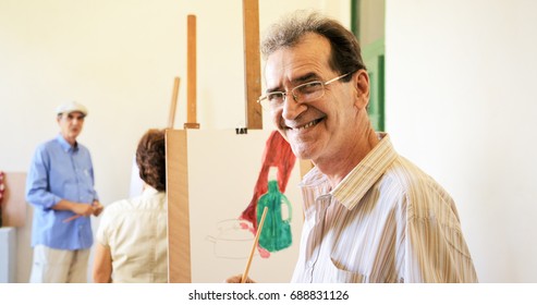 Elderly People Painting For Hobby. Group Of Active Seniors At Art School. Portrait Of Happy Old Man Smiling, Looking At Camera.