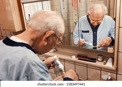 Elderly Person In The Bathroom, Brushing The Teeth