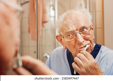 Elderly Person in the Bathroom, Brushing the Teeth - Powered by Shutterstock