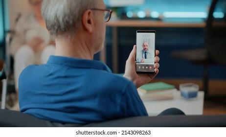 Elderly Person Calling Doctor On Videoconference To Attend Consultation, Using Mobile Phone For Telemedicine And Telehealth. Retired Adult Talking To Specialist On Online Remote Video Call.