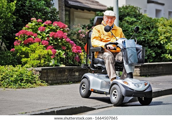 An elderly\
person drives an electric\
vehicle