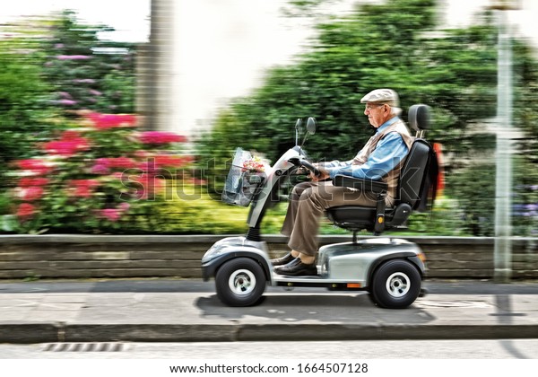An elderly\
person drives an electric\
vehicle