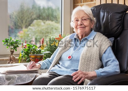 Elderly Person with Emergency Button Sitting in the Living Room