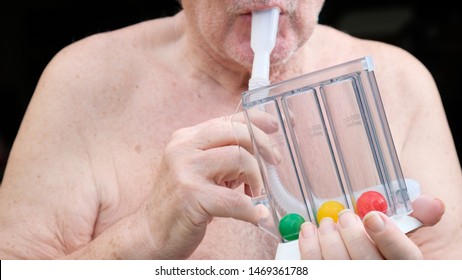 Elderly Person Using Incentive Spirometer For Lung  After Heart Surgery So That Lung Competent Capacity And Strong After Recovery