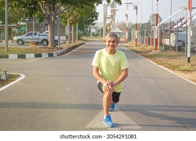 Elderly Retired Man Is Stretching His Legs Before Running Or Jogging, Concept Warm Up Exercise Prevent Injury In Elderly People