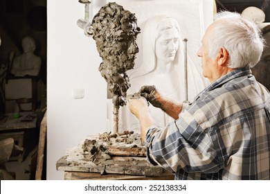 Elderly sculptor making sculpture profile view