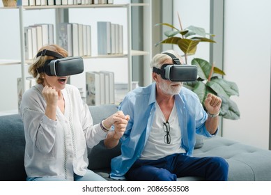 Elderly senior family couple in casual outfit using virtual reality device to play a game with exciting and joyful emotion in living room. - Powered by Shutterstock
