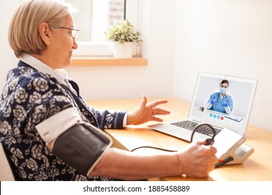 Elderly Senior Retired Woman Using Sphygmomanometer Blood Pressure Monitor To Measure Heart Rate Pulse,talking To Female E-doctor Via Online Video Call Help Line,self-monitoring Remote Telemedicine 