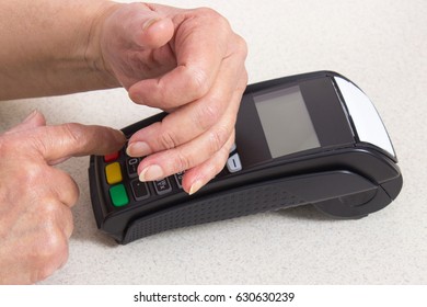 Elderly Senior Woman Covering Hands Whilst Entering Personal Identification Number On Payment Terminal