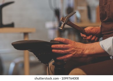 An elderly shoemaker at work in the workshop - Powered by Shutterstock