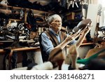 Elderly shoemaker working in a shop