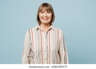 Elderly smiling cheerful fun happy cool optimist woman 50s years old wearing light striped shirt looking camera isolated on plain pastel blue cyan color background studio portrait. Lifestyle concept - Shutterstock ID 2286709177