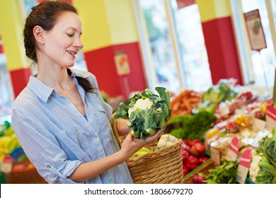 Elderly Smiling Woman Buys A Fresh Cauliflower In A Health Food Store