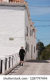 Elderly Spanish Woman In Black Walking In White Village Street. Mijas, Andalusia