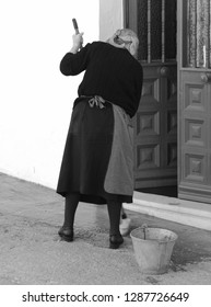 Elderly Spanish Woman Mopping Doorstep, Mijas Village, Andalusia