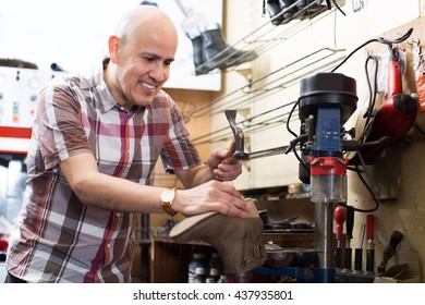 Elderly Specialist Fixing Heel Taps Of Shoes On Machine