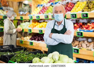 Elderly Supermarket Employee Wearing A Protective Mask Works In The Sales Area