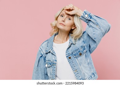 Elderly Tired Exhausted Sad Woman 50s Wearing Denim Jacket Put Hand On Forehead Suffer From Headache Isolated On Plain Pastel Light Pink Background Studio Portrait. People Lifestyle Fashion Concept