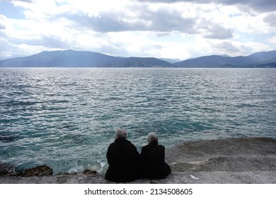 Elderly Tourist Couple Enjoying The Sea, During The Clean Monday.
Clean Monday Is Celebrated 50 Days Before Orthodox Easter.
Arvanitia Beach,Nauplio,Peloponnese,Greece,March 7,2022.
