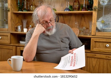 Elderly Veteran Reading Eviction Notice.  

Terrified Old Man Sitting And Reading The Eviction Notice He Just Received.  
