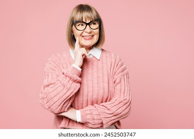 Elderly woman 50s years old wear sweater shirt casual clothes glasses put hand prop up on chin, lost in thought and conjectures isolated on plain pastel light pink background studio. Lifestyle concept - Powered by Shutterstock