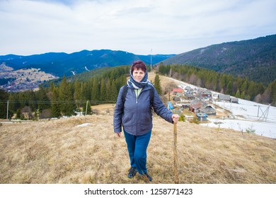 Elderly Woman 60 Years Old Hiking In Mountains With Snow Admiring Beautiful Valley View