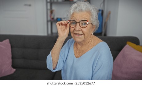 Elderly woman adjusting glasses indoors, showcasing positivity, comfort, and style in a living room - Powered by Shutterstock