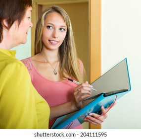 Elderly Woman Answers The Questions Of Smiling Employee  In Door