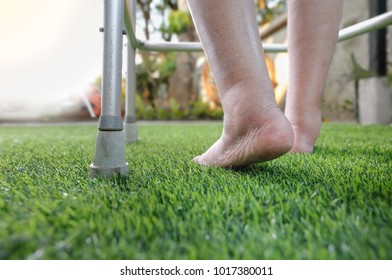 Elderly Woman Bare Swollen Feet On Grass With Walker 