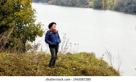 Elderly Woman By The River In Autumn While Walking