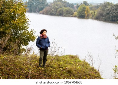 Elderly Woman By The River In Autumn While Walking