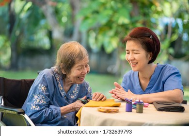 Elderly woman with caregiver in the needle crafts occupational therapy  for Alzheimer’s or dementia
