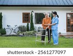 Elderly Woman with Caregiver Walking in Garden Outside Home, Enjoying Fresh Air and Nature, Senior Care and Support Concept