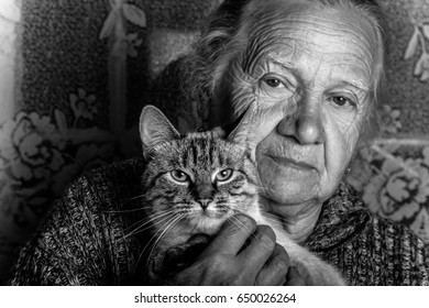 Elderly woman with cat in rustic interior. Toned.