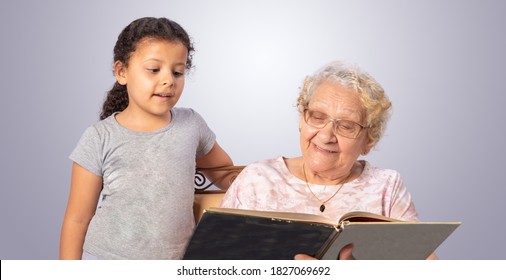 Elderly Woman And Child Reading A Book, Gray Gradient Background, Selective Focus.