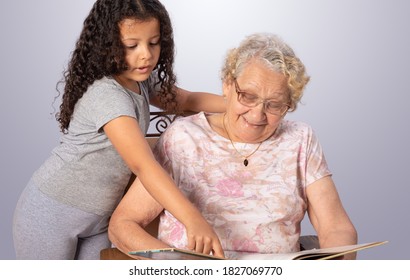 Elderly Woman And Child Reading A Book, Gray Gradient Background, Selective Focus.