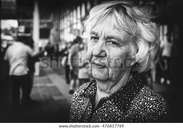 Elderly woman in\
the city. Black and white\
photo