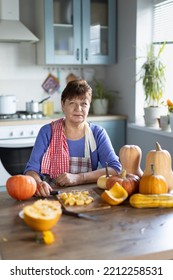 Elderly Woman Cooking Pumpkin In The Kitchen